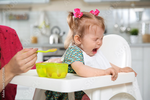 Fotografía Mother feeding her little baby with healthy food in kitchen