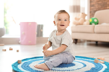 Sticker - Adorable little baby playing with wooden blocks at home