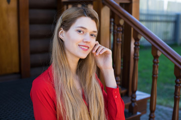 Wall Mural - Beautiful young blonde girl in red blouse. Street fashion look.