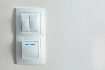 Three white lighting switch on wall