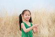© zilvergolf - Portrait of Asian child girl relaxing in summer field outdoor.