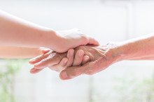 Close Up Of Young Woman Hand Holding With Tenderness An Elderly Senior Person Hands,people,age,family,care And Support Concept