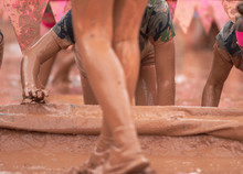 Mud Race Runner Women Crawling In The Mud Under Obstacles