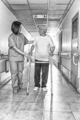 Poster - Asian doctor helping elder man with walker in hospital hallway