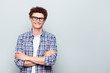 © deagreez - Portrait with copy space and empty place for text with young man in glasses with crossed arms looking at camera isolated on light grey background