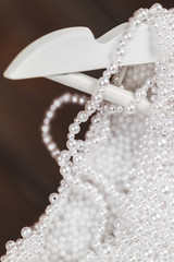 Wall Mural - Details of shining wedding dress with pearls and gemstones closeup