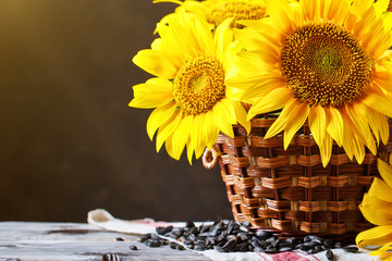 Fotomurales - Beautiful sunflowers in a basket on a wooden table.