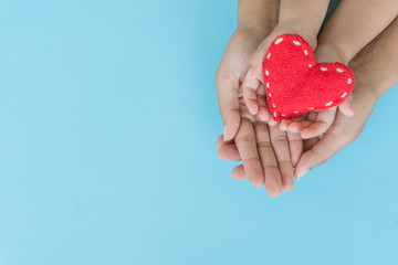 Top view of adult and child holding red heart in hands, Happy family relationships, Valentine's day, Mother's Day, Love and health care concept.