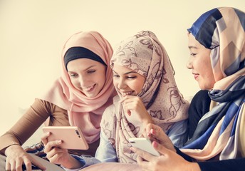 Wall Mural - Group of islamic women talking and watching on the phone together