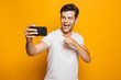 © Drobot Dean - Portrait of a cheerful young man taking a selfie