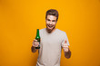 © Drobot Dean - Portrait of a cheerful young man holding beer bottle