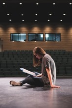 Female Actress Reading Script On Stage