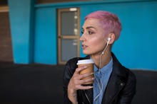 Stylish Woman Having Coffee While Waiting At Railway Platform