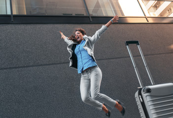 Wall Mural - Success, cheerful businesswoman jumping on street.