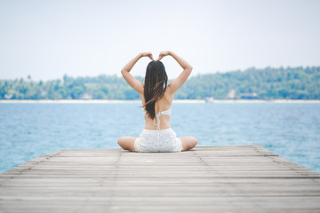 Wall Mural - Woman making heart sign on bridge