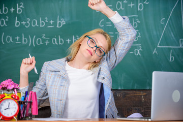 Wall Mural - Exercises to maintain vivacity. Teacher woman sit table classroom chalkboard background. Stretch and do exercises to increase vivacity and get energy charge. Work far beyond actual school day