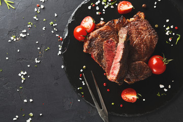 Sticker - Rare rib eye steak on dark plate, top view