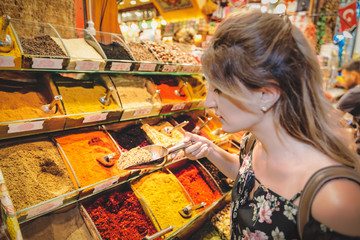 Beautiful woman smells different kind of spices in Egypt Bazaar