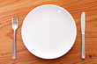 © jedi-master - 木製テーブルに置かれた白い皿とカトラリー