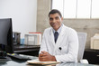 © Monkey Business - Mixed race  male doctor at desk, portrait