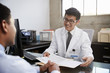 © Monkey Business - Happy Asian male doctor in consultation with male patient