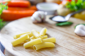 Sticker - Italian pasta rigatoni over the wooden board.