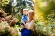 © justesfir - Beautiful woman with child outdoors in summer, mother and son as parenting concept