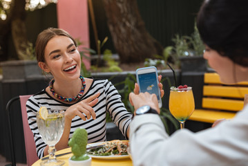 Wall Mural - Planning picnic. Two beautiful best friends planning weekend picnic checking weather forecast