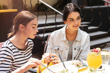 Wall Mural - Cunning woman. Cunning dark-haired woman putting fork from the fancy restaurant to her bag