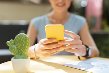 Wall Mural - Checking e-mail. Busy experienced freelancer checking her e-mail on yellow smart phone