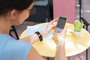 Wall Mural - Bank app. Busy smart businesswoman feeling curious while opening her bank app on smart phone