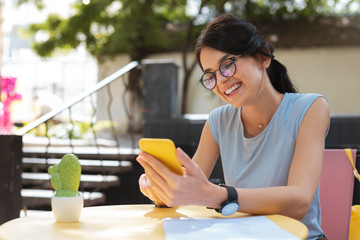 Wall Mural - Nice message. Beautiful dark-haired woman smiling broadly receiving nice message from boyfriend