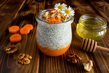 Wall Mural - Pudding with chia,carrot,walnuts  and honey on the brown  wooden background