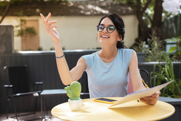 Wall Mural - Starter and drink. Smiling fashionable woman calling waiter after choosing starter and drink