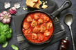 © lilechka75 - Spicy meatballs in tomato sauce in a cast iron pan.Top view.