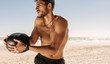© Jacob Lund - Man training at the beach using a medicine ball