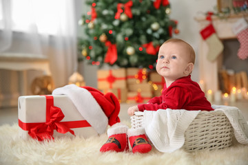 Wall Mural - Cute baby sitting in basket at home. Christmas celebration