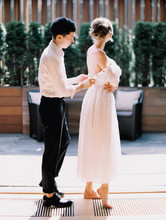 A Groom Helping His Bride With A Dress