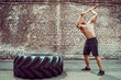 © zamuruev - Sport Fitness Man Hitting Wheel Tire With Hammer Sledge Crossfit Training, Young Healthy Guy Gym Interior OUTSIDE