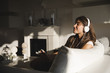 © Michela Ravasio/Stocksy - Smiling young woman listening the music on sofa