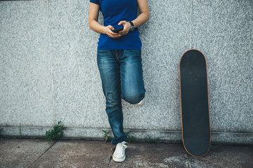 one skateboarder use mobile phone on city