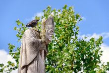 Paris, France - August 10, 2017. Statue Of Saint Denis, The First Bishop Of Paris, Martyr Holding His Head In Hands By Summer Day On Montmartre Hill Park. Pigeon Sitting On Beheaded Bishop's Statue.