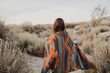 © vladteodor - Back side of boho woman in the desert nature.  Artistic photo of young hipster traveler girl in gypsy look and windy hair, in Coachella Valley in a desert valley in Southern California.