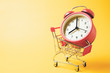 Buy time, Shopping cart with red vintage alarm clock show 8 O'clock over yellow background