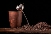 Picture Of The Tea Strainer With Dried Tea Leaves And Sticks Of Cinnamon Isolated On Dark Wooden Background