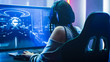 Shot of the Beautiful Pro Gamer Girl Playing in First-Person Shooter Online Video Game on Her Personal Computer. Casual Cute Geek wearing Glasses and Headset. Neon Room. eSport Cyber Games Event.