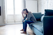 © SB Arts Media - Young attractive latin woman lying at home living room couch feeling sad tired and worried suffering depression in mental health, problems and broken heart concept.