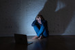 Sad and scared female Young woman with computer laptop suffering cyberbullying and harassment being online abused by stalker or gossip feeling desperate and humiliated in cyber bullying concept.