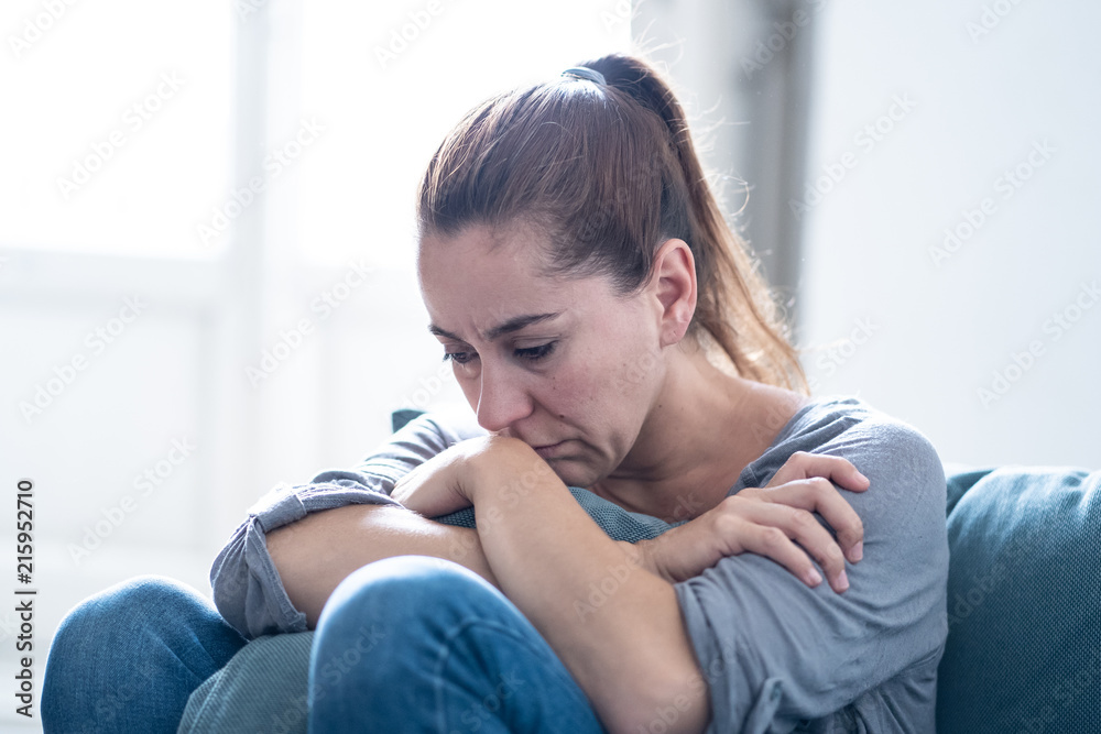 Young attractive latin woman lying at home living room couch feeling sad tired and worried suffering depression in mental health, problems and broken heart concept. - obrazy, fototapety, plakaty 