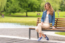Young Woman Sitting On Bench In Park